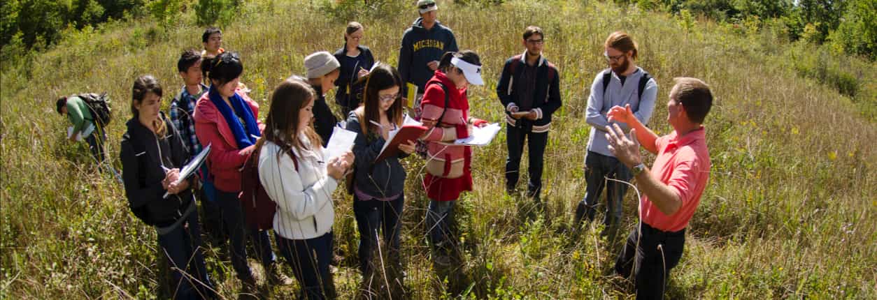 An image of a group of students learning in a field